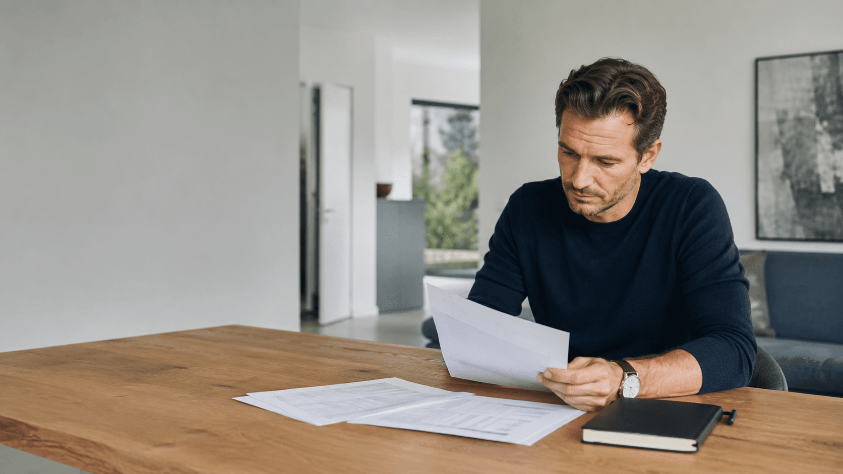 Eine Person prüft Darlehensunterlagen und eine persönliche Finanzübersicht vor der Entscheidung über eine Sondertilgung.